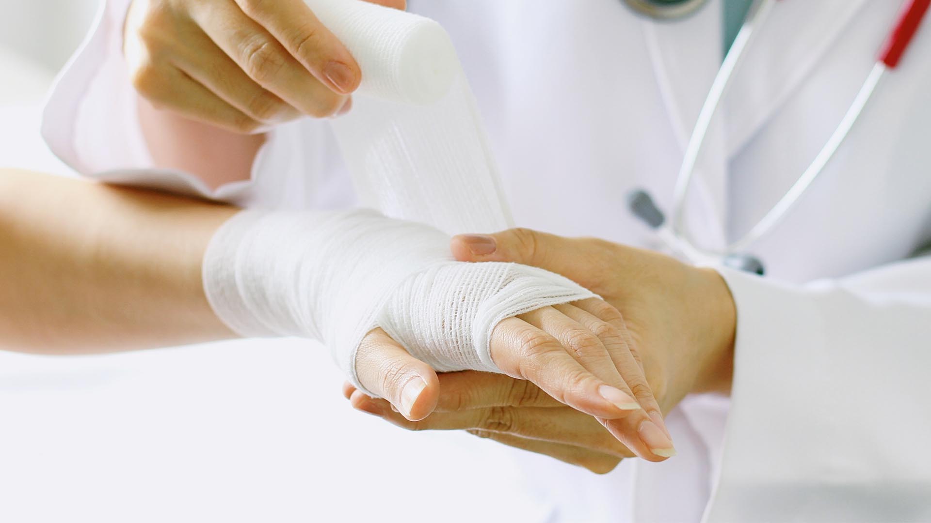 doctor bandaging patient wrist